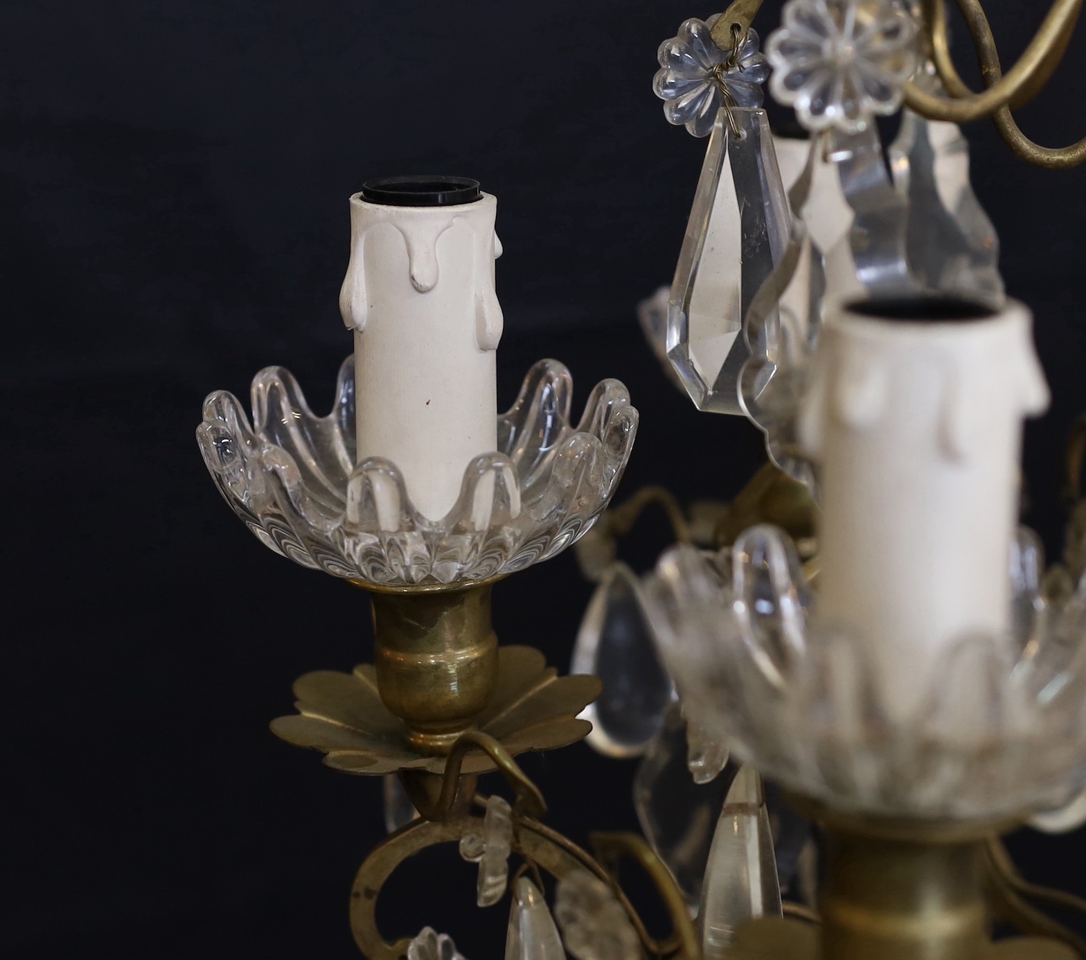 An early 20th century French bronze and cut glass six light chandelier hung with tear and lozenge shaped drops, drop 50cm. width 35cm